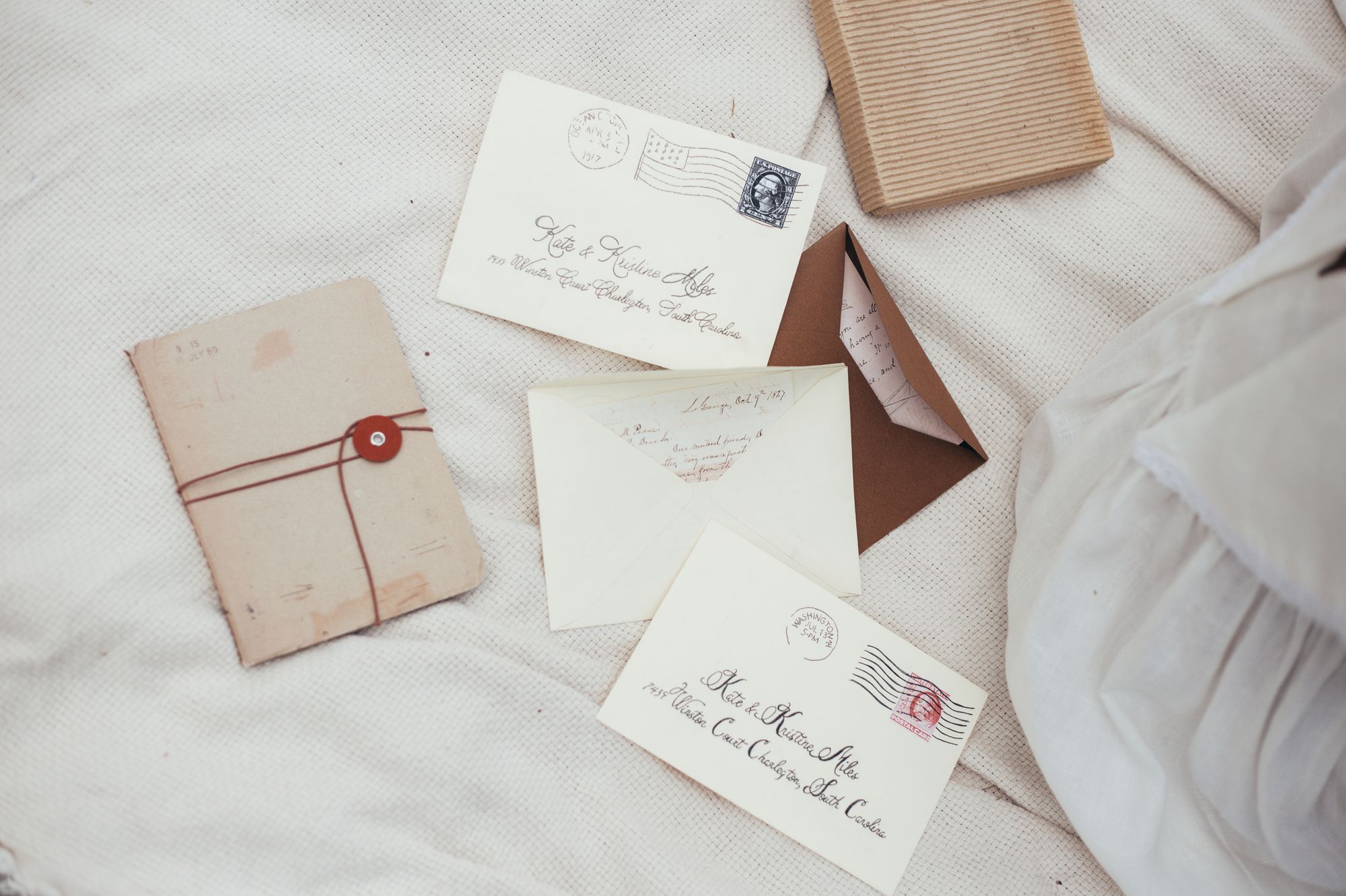 Old letters and a wax-sealed envelope tied with string on white linen